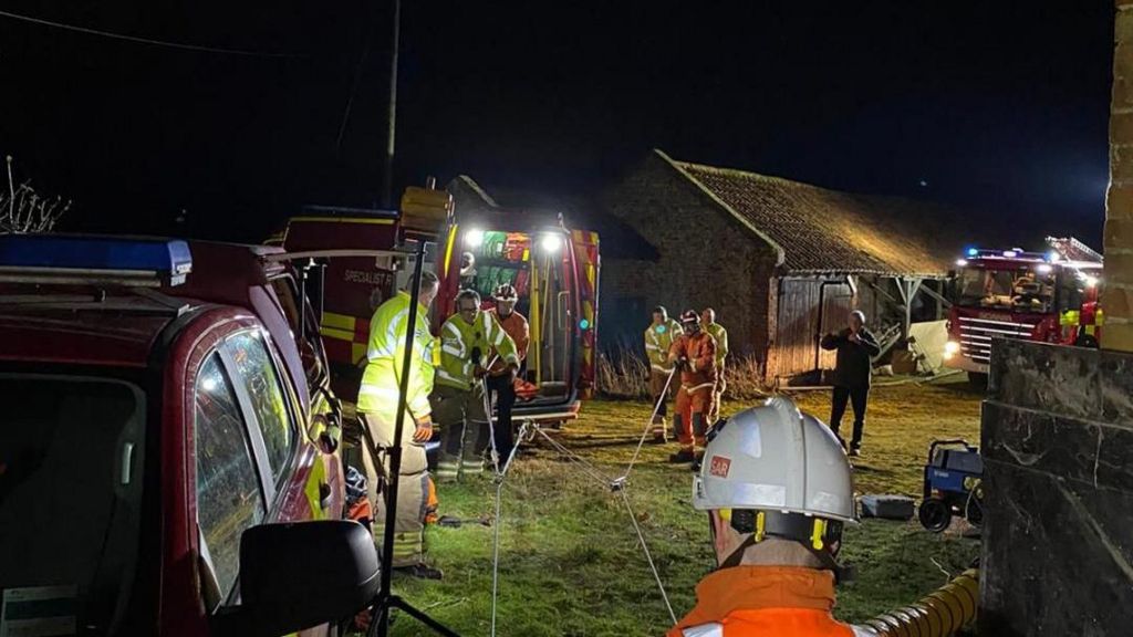 Firefighters working to get a dog out of a well in Great Chesterford, Essex