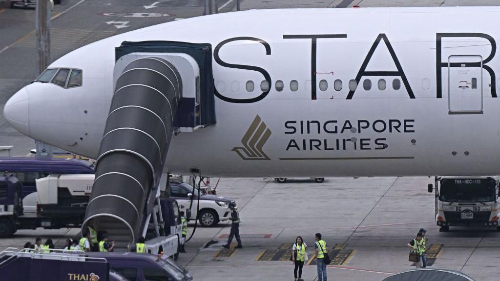 Singapore Airlines Boeing 777-300ER airplane parked on tarmac at Suvarnabhumi International Airport in Bangkok.