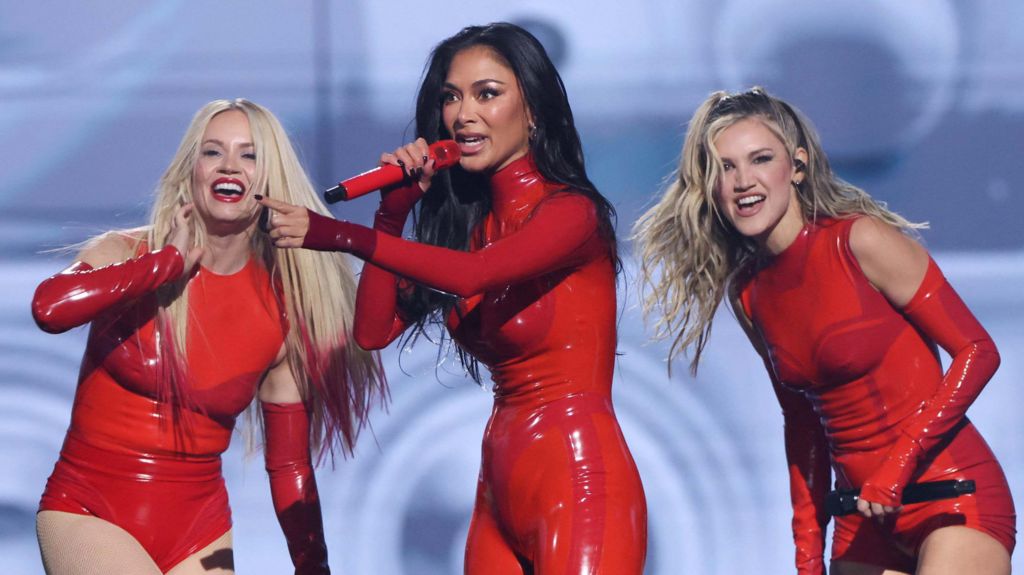 Singers Kimberly Wyatt, Nicole Scherzinger and Ashley Roberts of The Pussycat Dolls perform on stage wearing red PVC outfits