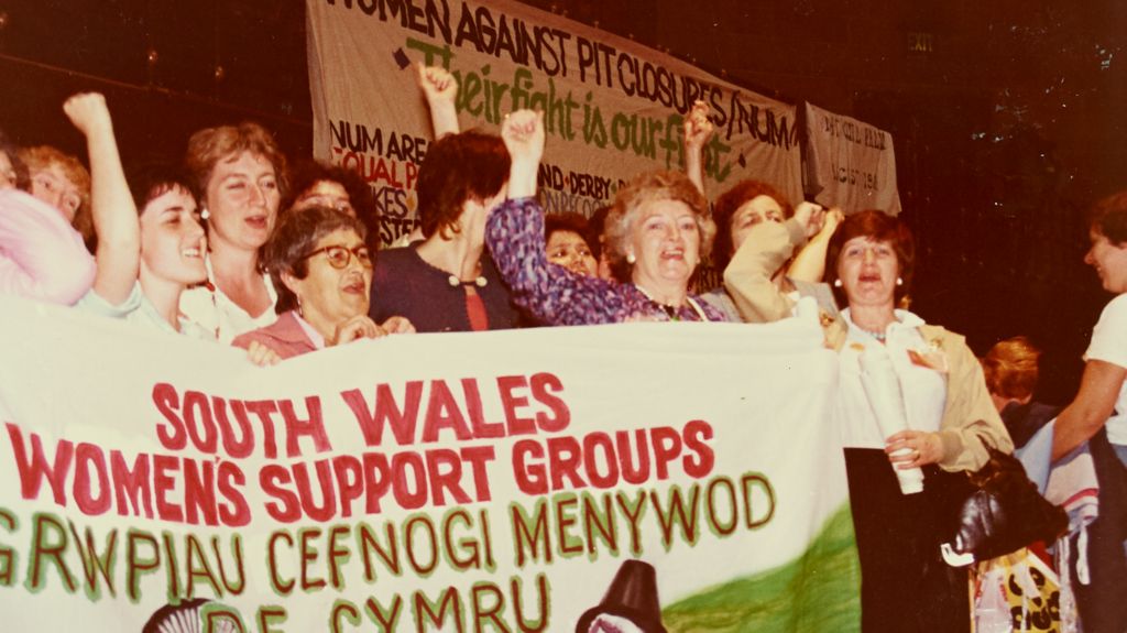 Women from a miners' support group holding a banner