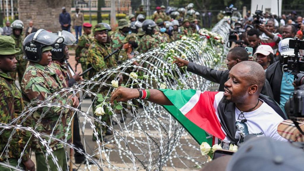 Protesters place flowers on barbed wire
