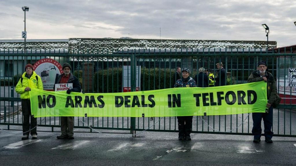 Protesters hold up a banner reading "no arms deals in Telford"