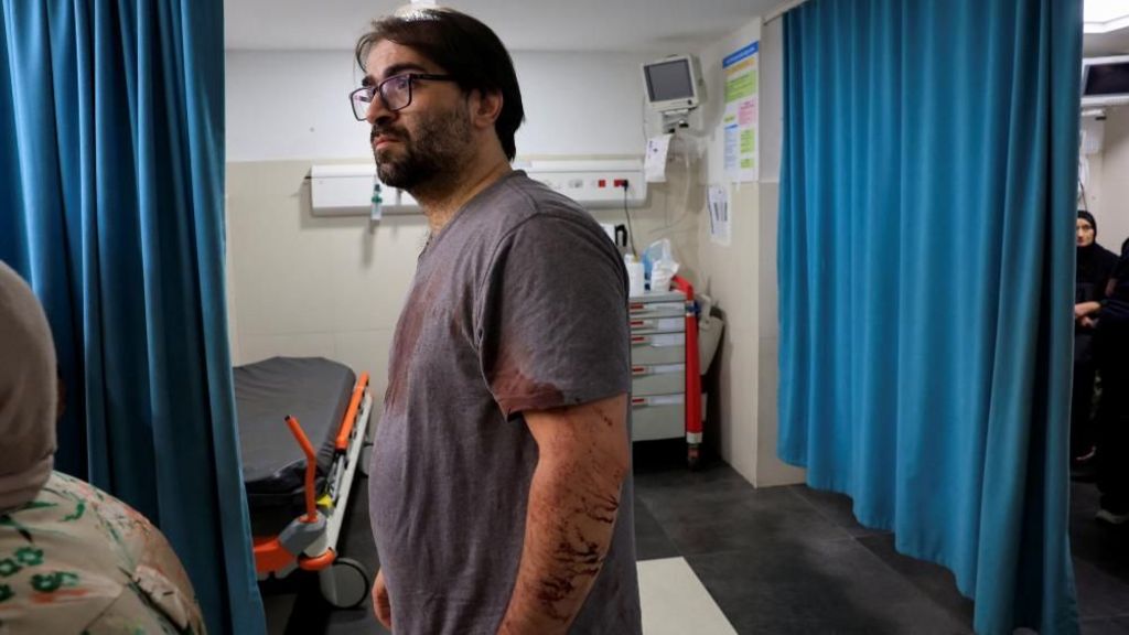 A Palestinian father stands in a Hebron hospital emergency room with his clothes stained with blood. His his seven-month-old baby was killed by Israeli forces, the Palestinian health ministry said. Photo: 5 June 2026