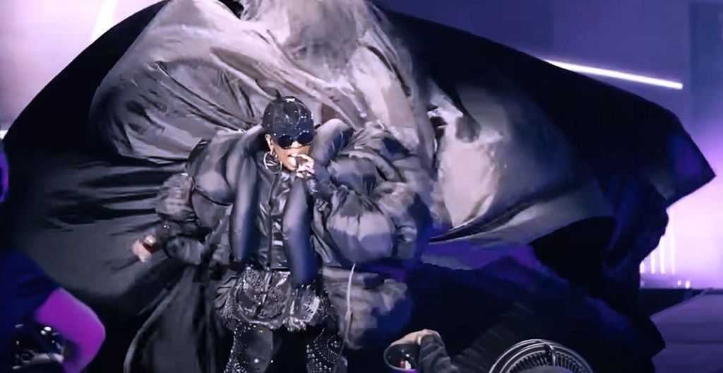 Missy Elliot performs in a black cyberpunk outfit, with a long billowing train