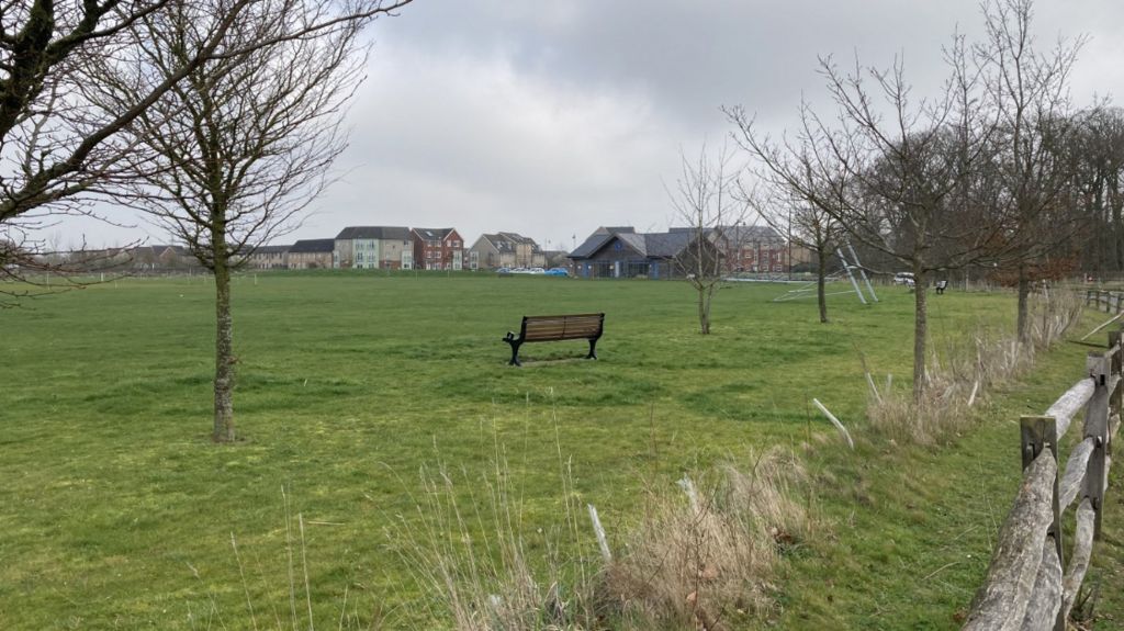 Image of green field with a bench in Cambourne