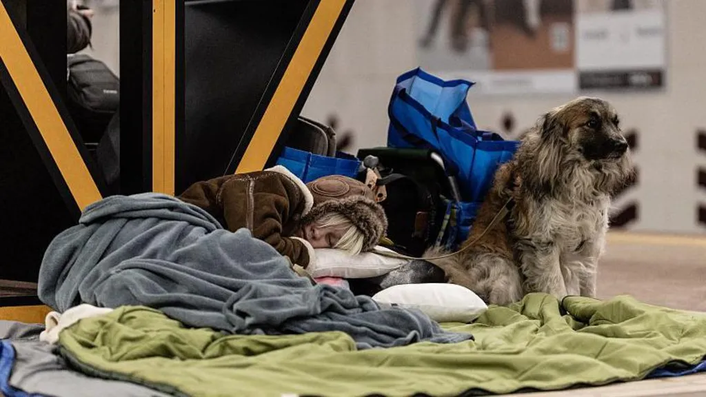 A young woman sleeps on the floor of a metro station beside her dog during an overnight sheltering, in Kyiv, Ukraine on February 7, 2026. 