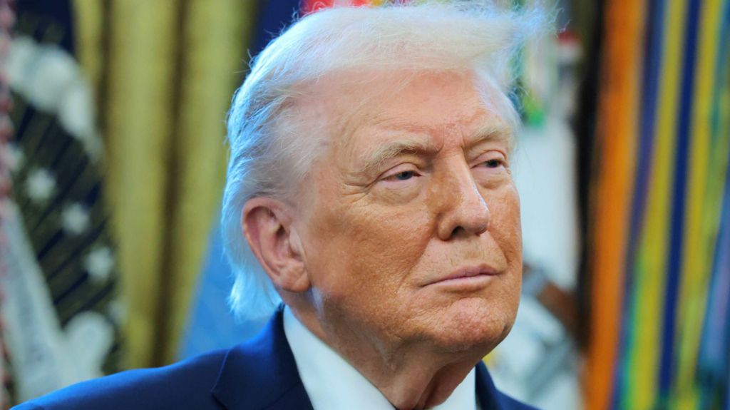 President Trump in the Oval office wearing a white shirt and blue suit