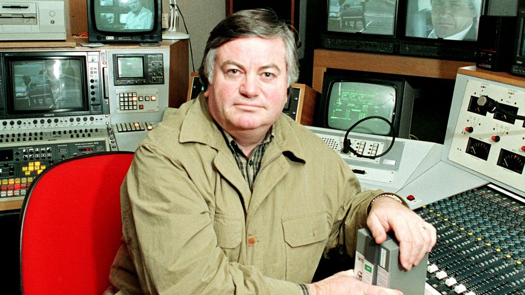 Roger Cook in a TV editing suite, wearing a khaki jacket