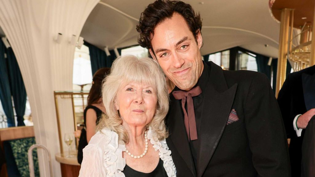 Dame Jilly Cooper and Alex Hassell attend the Disney+ BAFTA TV Awards Reception at Raffles Hotel on May 11, 2025 in London, England.