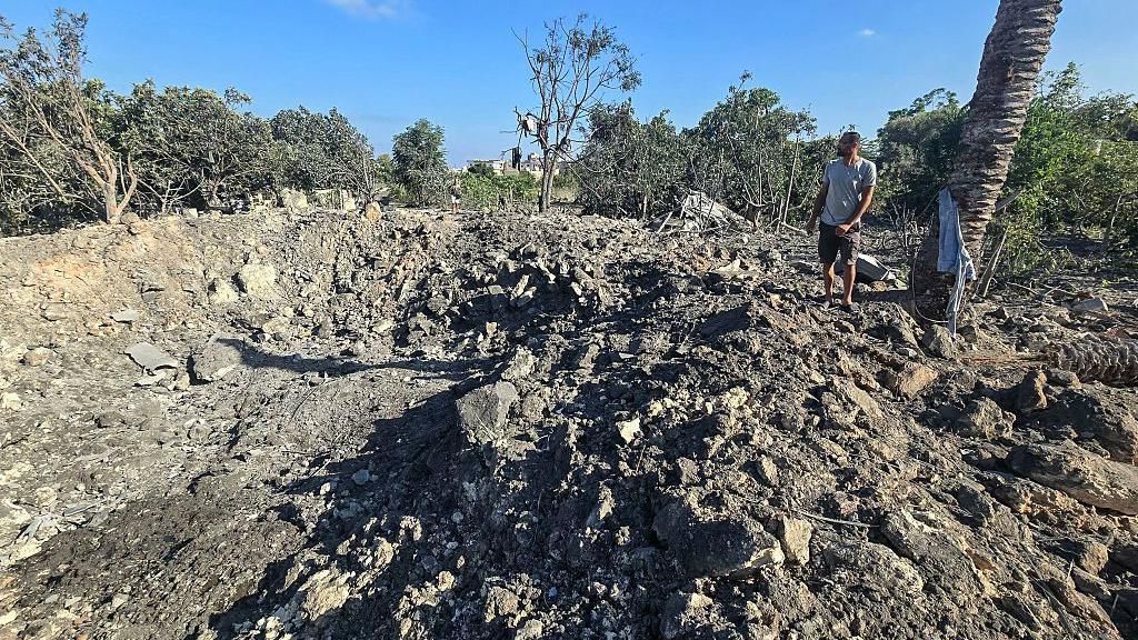 A man stands by a crater left by an overnight Israeli air strike on a house in the area of Burj al-Shamali, near Tyre, southern Lebanon (6 August 2026)