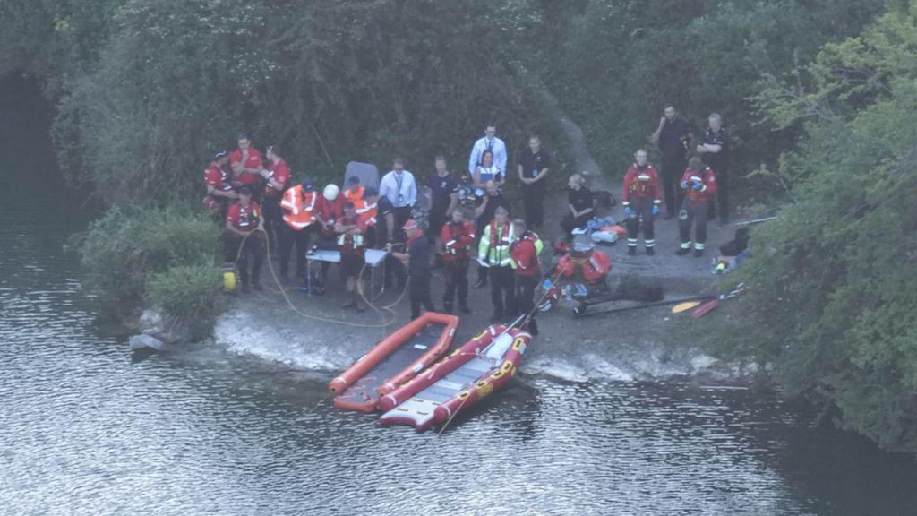 Search and rescue teams at the side of a pond