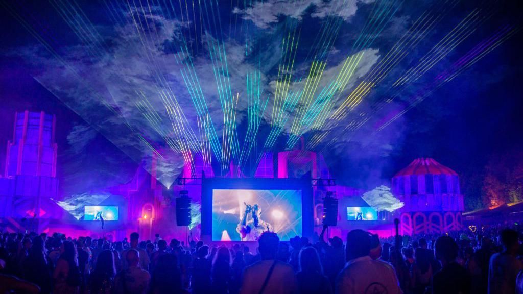 General view of the crowd, stage, screens and lightshow during a performance after dark at Boowtown Festival, Matterley Estate in South Downs National Park, near Winchester, Hampshire