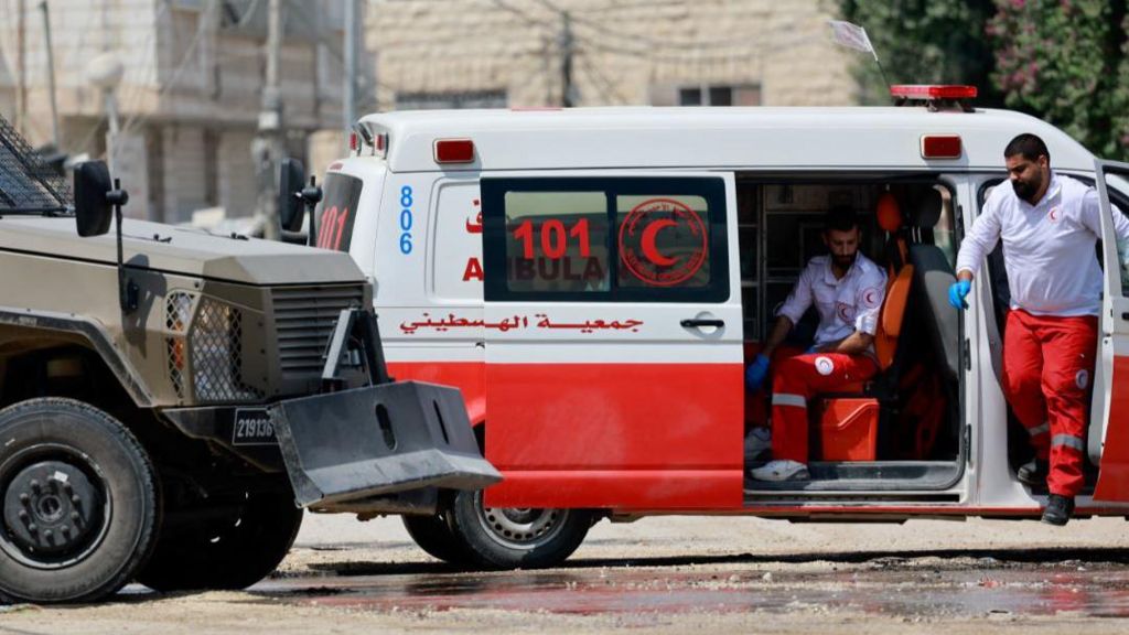 An ambulance and a police vehicle stand during an Israeli raid in Jenin, in the Israeli-occupied West Bank, 31 August