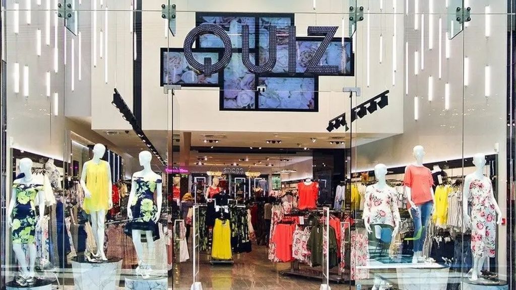 Storefront of a Quiz shop. There are summer clothes on the mannequins in the windows