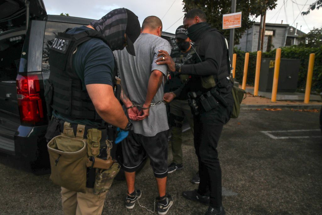 Ice agents arresting a migrant during a raid in Los Angeles in September 2022