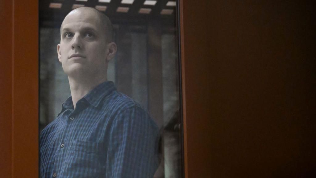 Gershkovich stands inside the defendant's cage during a hearing