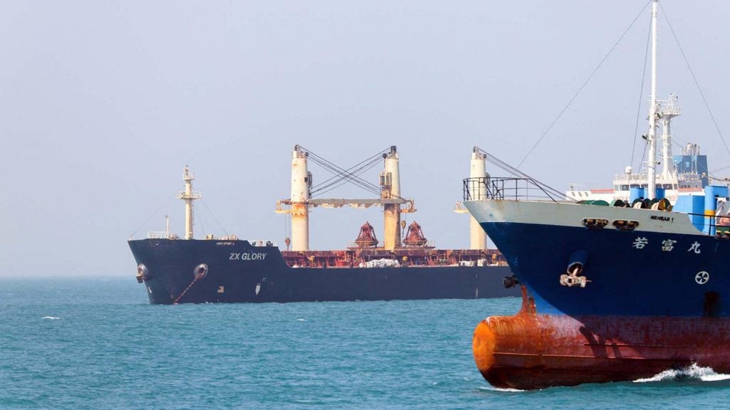 Two blue ships on a bright blue sea.