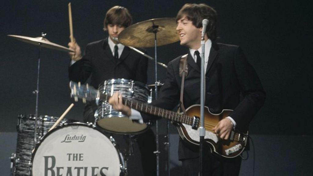 Ringo Starr drumming behind Beatles bandmate and bassist/singer Paul McCartney in 1964