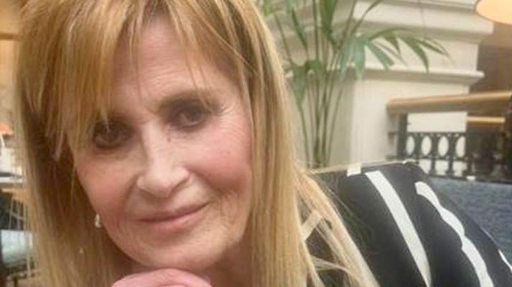 A woman with blonde hair looks at the camera 