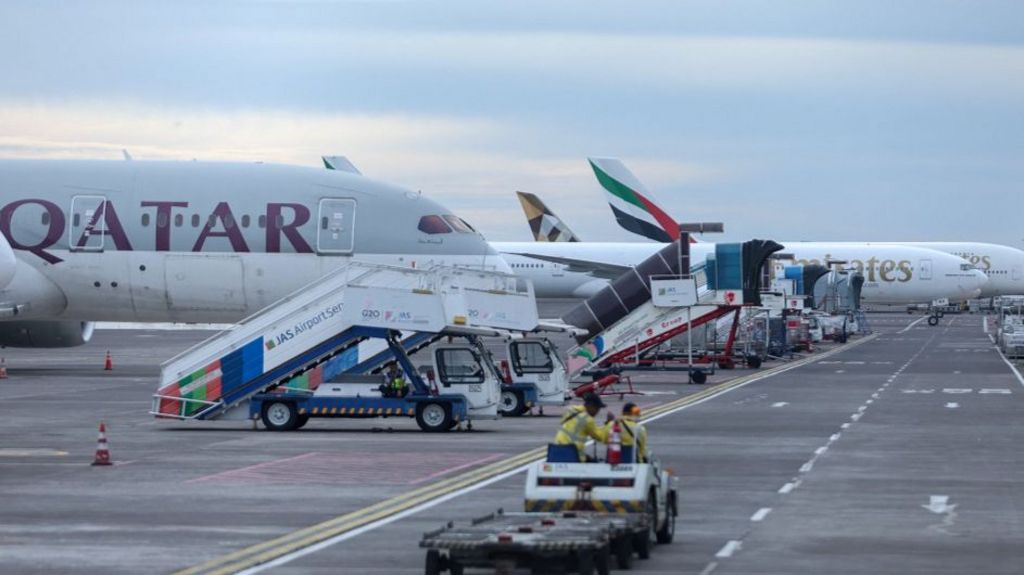 Emirates and Qatar Airways aircraft on the tarmac at I Gusti Ngurah Rai International Airport in Bali, Indonesia, after flight cancellations