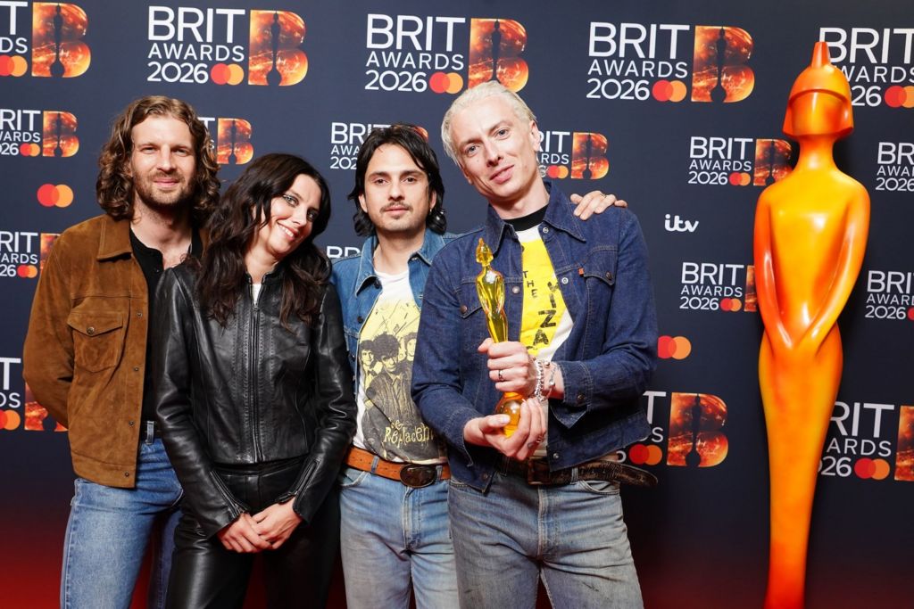 Wolf Alice hold their award up to the camera.