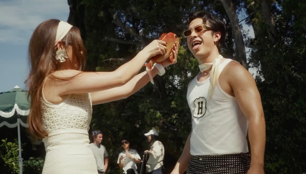 Laufey and Hudson Williams play with a prop fish on the set of her music video for Mad Woman
