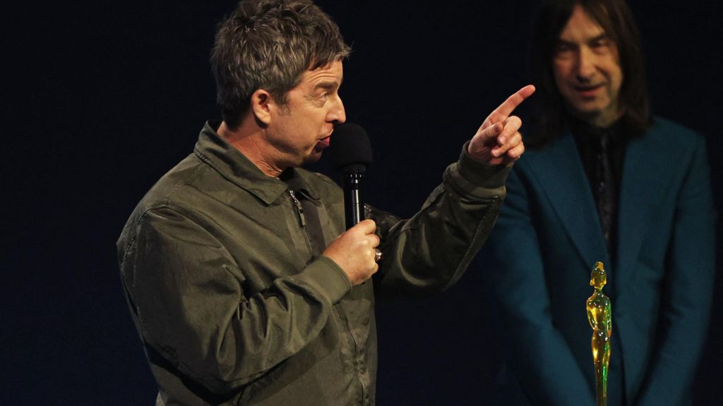 Noel Gallagher speaks as he accepts an award for Songwriter of the Year presented by Bobby Gillespie, during the BRIT Awards at the Co-op Live Arena in Manchester