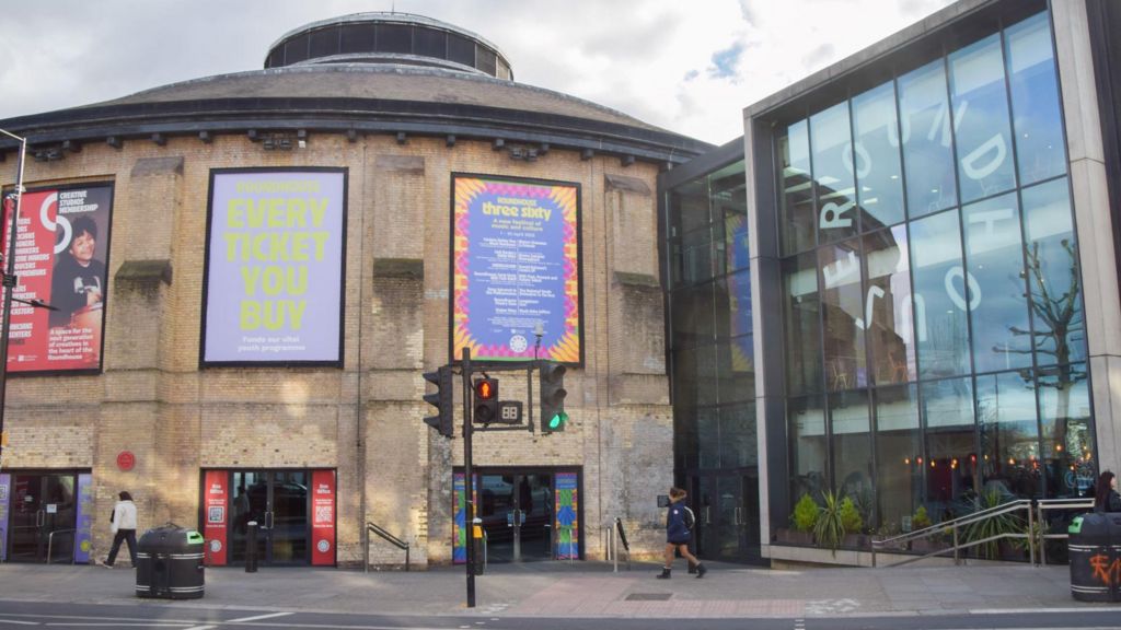An external image of the Roundhouse. A cylindrical building with a glass extension.