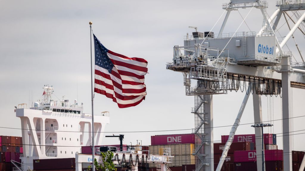 The American flag flies over cargo containers at the Port Liberty on August 07, 2025 in Bayonne, New Jersey.