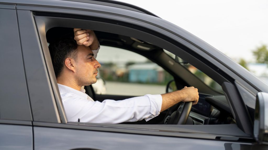 A man looking frustrated while driving his car