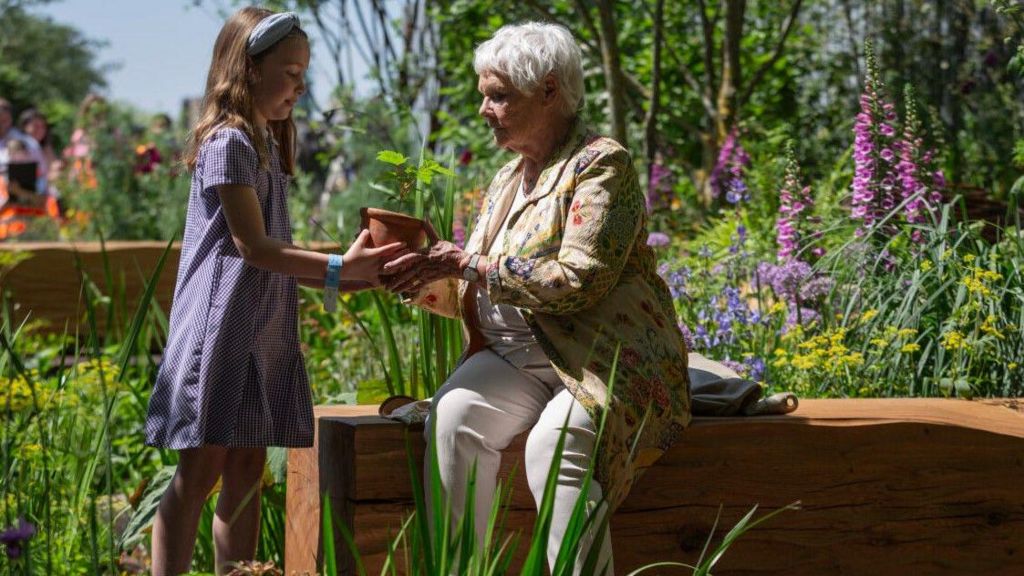 Charlotte (left) and Dame Judi holding the seedling at the National Trust's Octavia Hill Garden