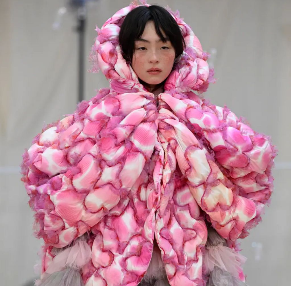 Model wearing large pink coat 