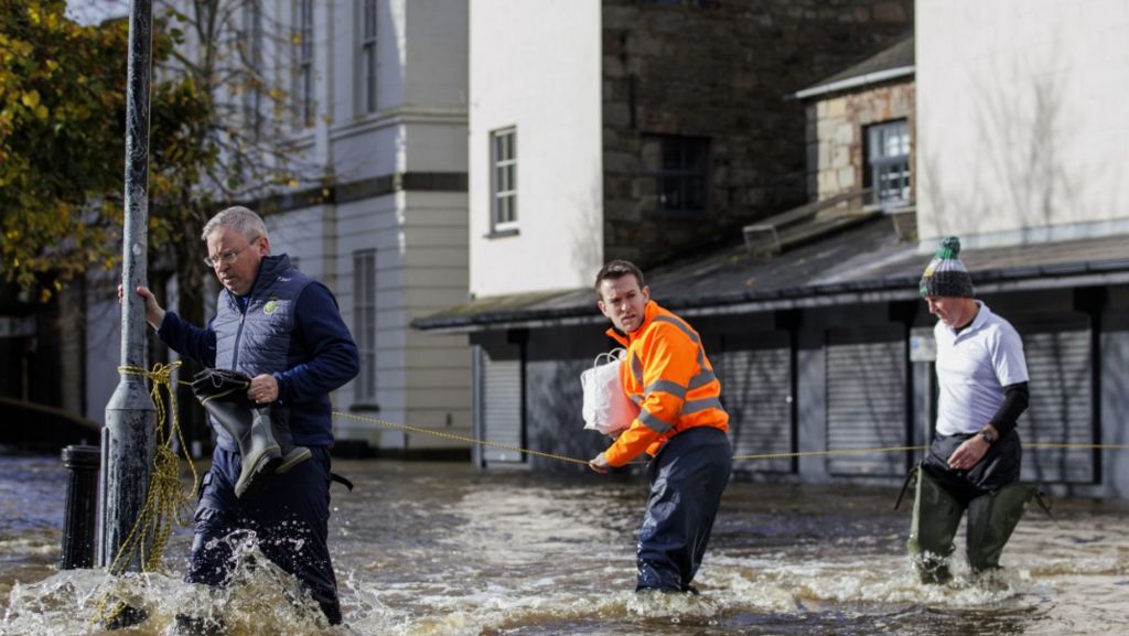 Three men in water at Bank Parade in Newry