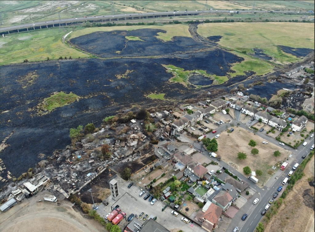 Blackened area between major road and housing, seen from above