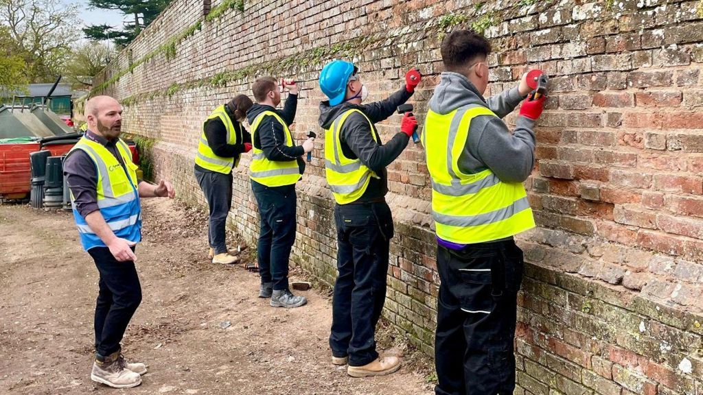 Bricklaying students working on a wall