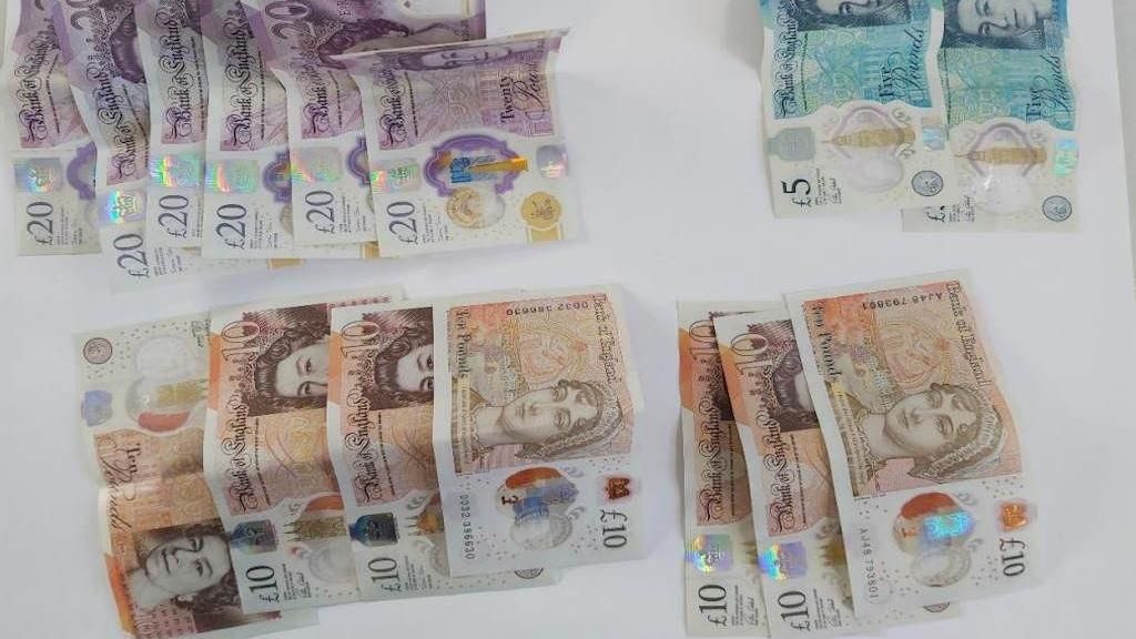 £20, £10 and £5 notes laid out on a white table