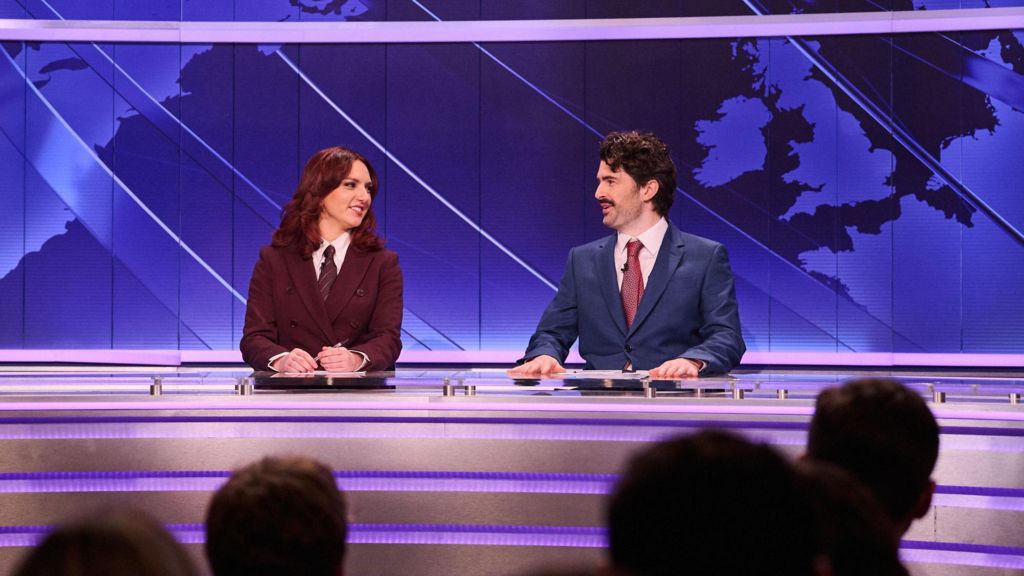 Ania Magliano and Paddy Young as news anchors at a set with a map of the world seen behind them
