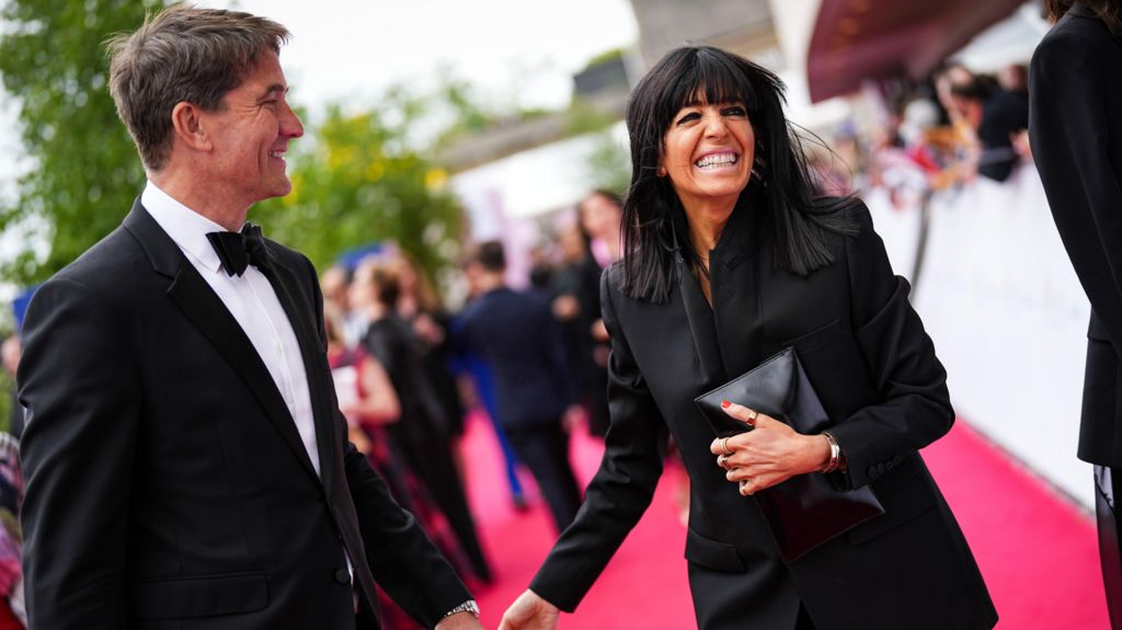 Claudia Winkleman smiling and holding hands with Kris Thykier