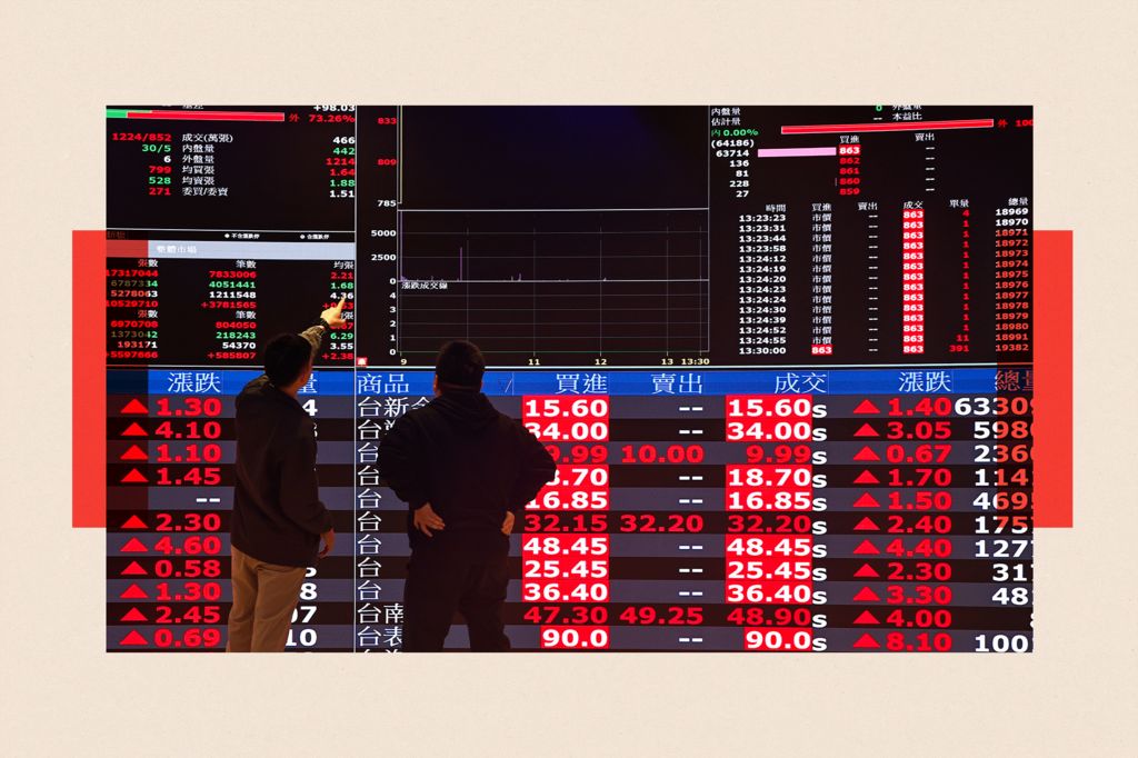 Two men discuss as they look at the screens showing surging stock shares at the Taiwan Stock Exchange office