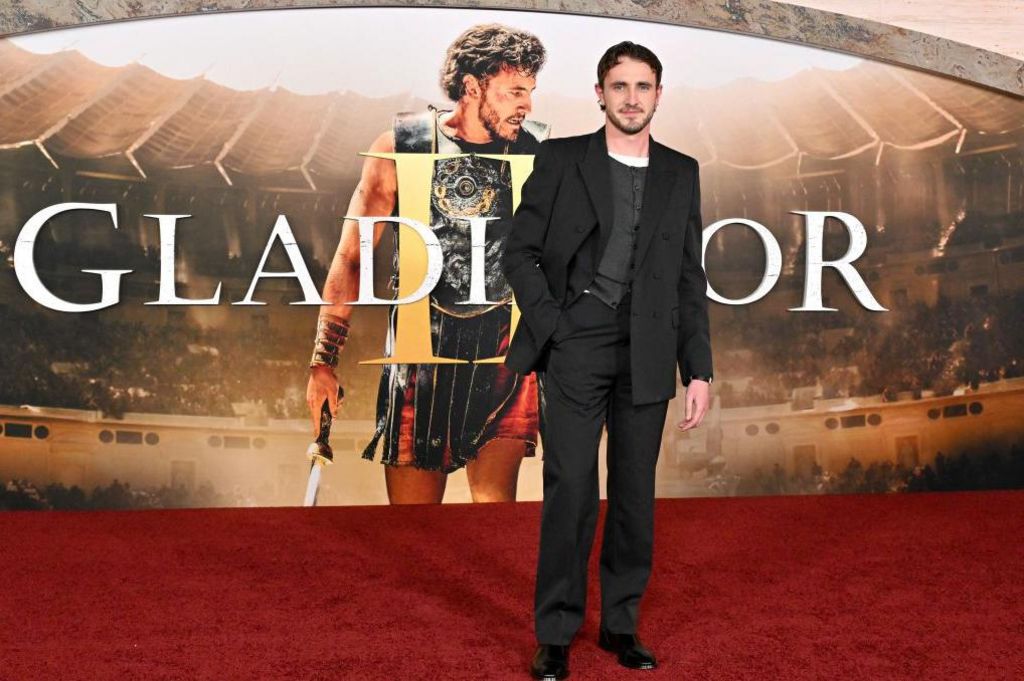 Mescal at the Los Angeles premiere of Gladiator II, standing in front of advertising showing him in character