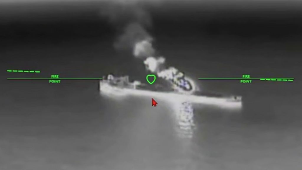A still image of an oil tanker under attack from a drone in a black and while nighttime image