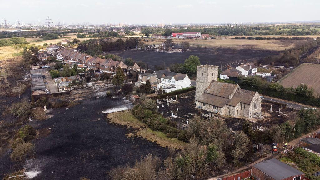 The scorched graveyard around a church following a large blaze in Wennington