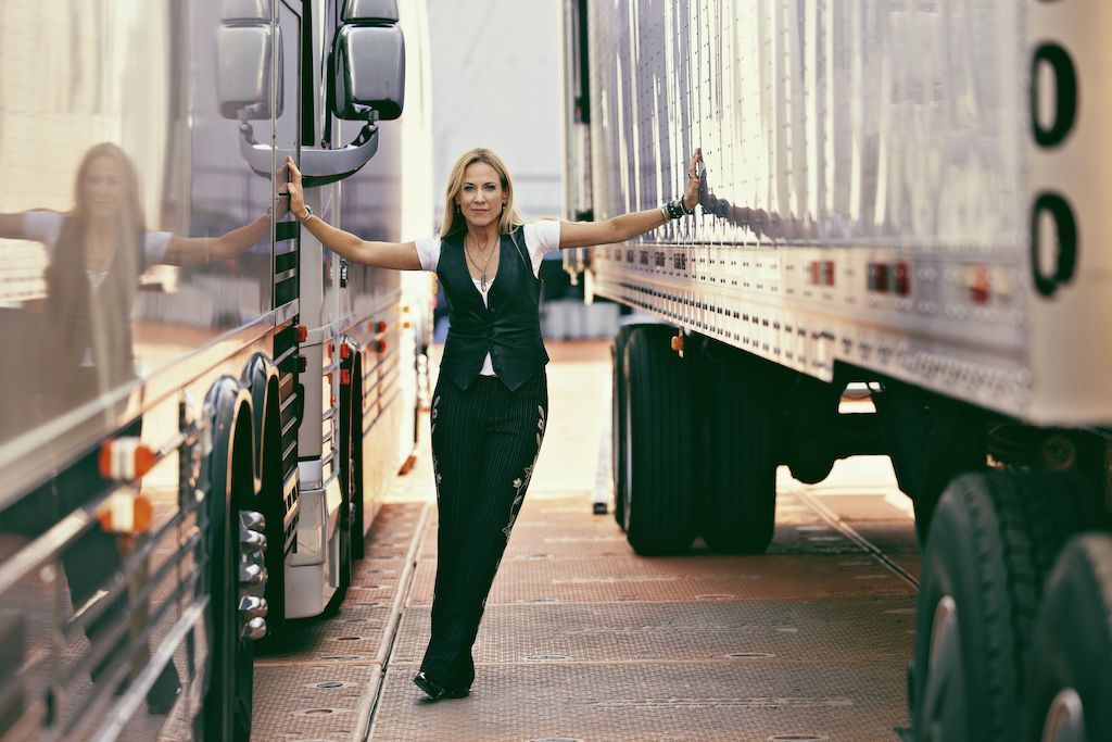 Sheryl Crow poses with her tour trucks