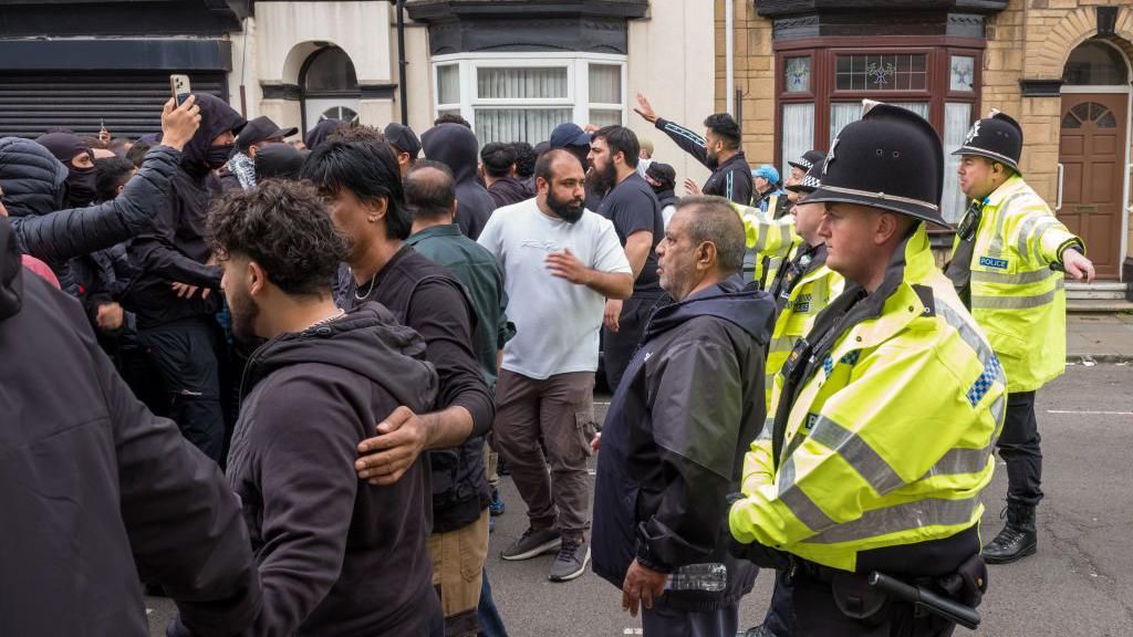 A group of men protect a mosque 