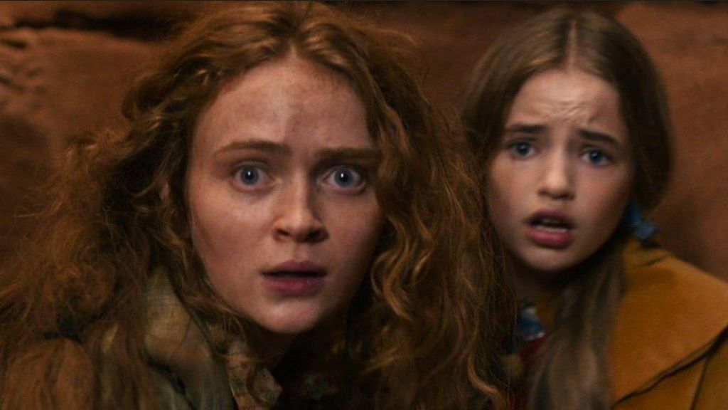 Sadie Sink and Nell Fisher looking frightened inside a cave