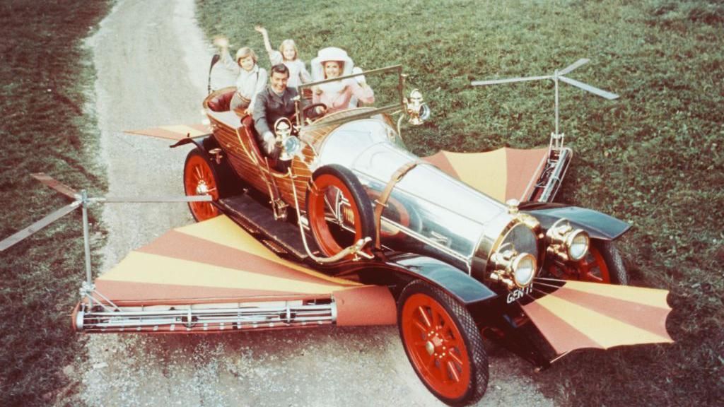 Dick Van Dyke, Heather Ripley, Adrian Hall and Sally Ann Howes sit waving from their seats in the car, in a publicity portrait issued for the film, 'Chitty Chitty Bang Bang', United Kingdom, 1968