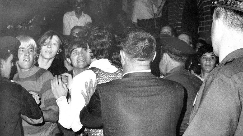  Crowd attempts to impede police arrests outside the Stonewall Inn on Christopher Street in Greenwich Village.