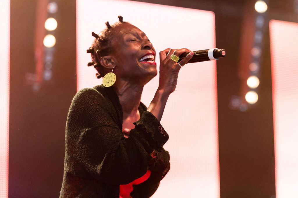 Alison Limerick sings passionately into a microphone while wearing large circular gold earrings and a cardigan at the Mighty Hoopla festival in London in 2017.