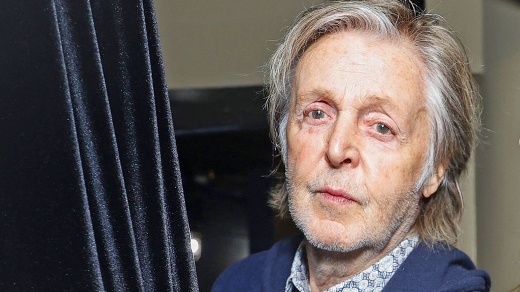 Headshot of musician Paul McCartney, wearing blue blazer and open-necked shirt, taken in 2023
