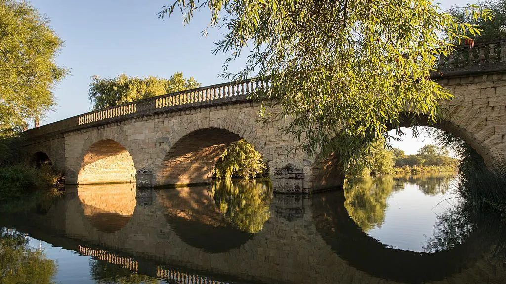 Early summer morning reflections on the River Thames at Swinford Toll Bridge on August 26, 2016 in Eynsham, England.